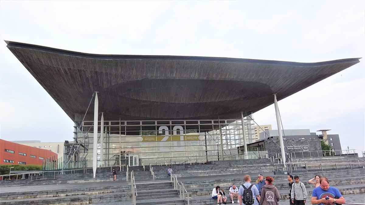 مبنى السنيد في خليج كارديف: واجهة زجاجية تحت سقف خشبي متموّج يمتد فوق المدخل