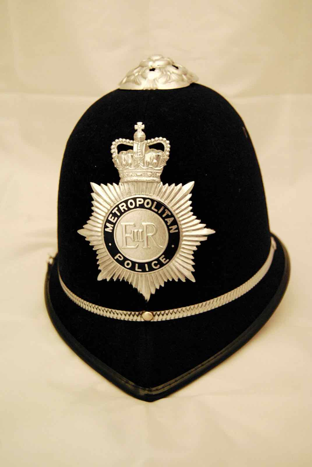 Il tradizionale elmetto alto blu scuro della polizia di Londra, con una placca argentata a forma di stella sul davanti