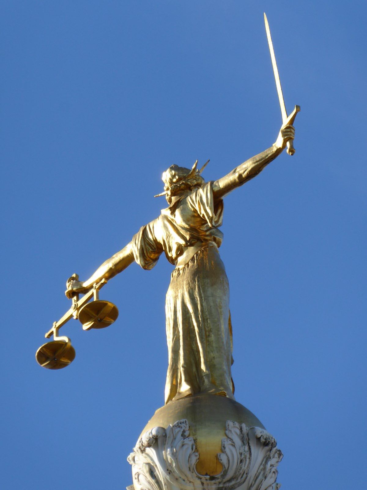 La statua dorata della Giustizia sulla cupola dell'Old Bailey a Londra, con una spada in una mano e una bilancia nell'altra
